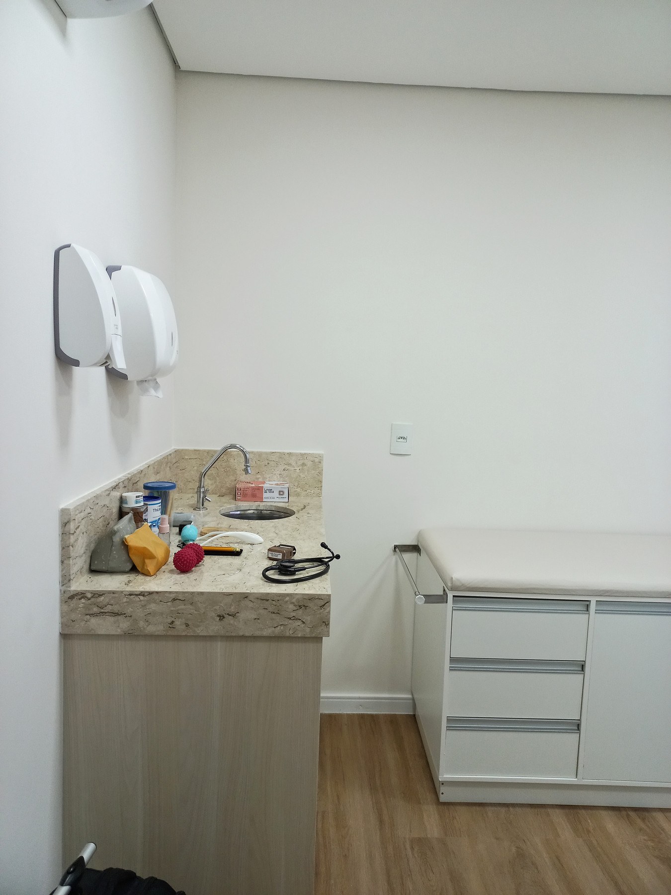 Sala de avaliação com pia e maca
